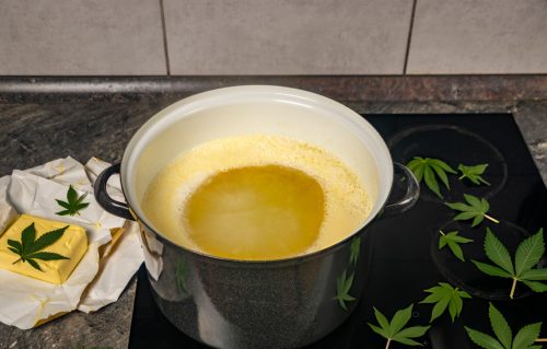 Cannabutter simmering on the stove with decarboxylated cannabis trim and butter